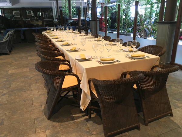 Imatge d'una taula d'un menjador del Restaurant Ramon al costat de la col·lecció de cotxes antics